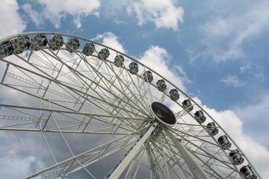 Mavi gökyüzü ve beyaz bulutlu büyük beyaz dönme dolap manzarası