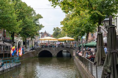 Alkmaar, Netherlands, September 3, 2024 - View of a water canal with a bridge and a street cafe clipart