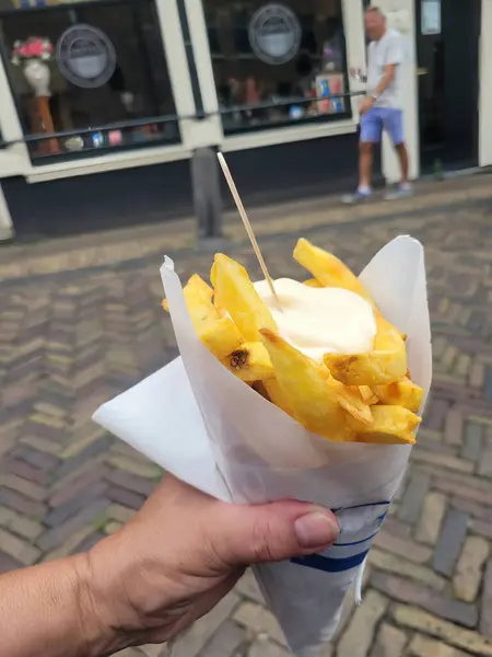 Patates kızartması bir torba içinde, bir insan eliyle, bir şehirde. 