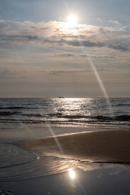 Deniz, kumlu sahil ve dalgalar alçak gelgitte güneşli