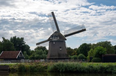 Hollanda 'da suyun üzerindeki yel değirmeni De Sluismolen