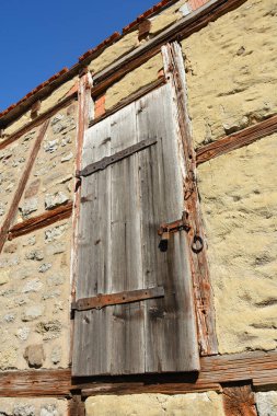 Eski bir kalenin duvarında kilitli ahşap bir kapı.