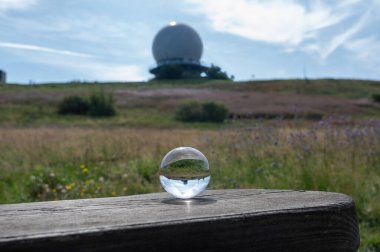 Radar kubbesinin yansıması olan tahta üzerine cam top. Almanya 'daki yüksek Rhoen' de Wasserkuppe 'nin zirvesinde kubbe. Mavi gökyüzü güneşli bir günde