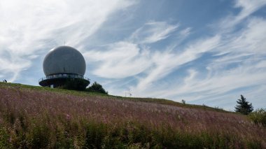 Radar kubbesi, Almanya 'nın yüksek Rhoen bölgesindeki Wasserkuppe zirvesinde, yeşil bir çayır ve pembe bir Willonerb ile, mavi gökyüzü ile güzel bir yaz günü