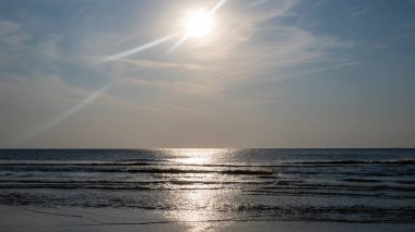 Kumlu bir sahilde dalgalar, güneşli deniz kenarında