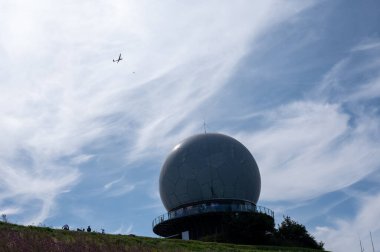 Radar kubbesi, kubbe, Almanya 'nın yüksek Rhoen bölgesinde Wasserkuppe' nin zirvesinde, mavi gökyüzünde bir planörle