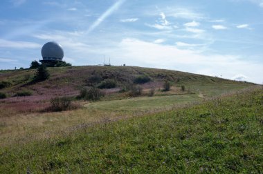 Radar kubbesi, Almanya 'nın yüksek Rhoen bölgesindeki Wasserkuppe zirvesinde, yeşil bir çayır ve pembe bir Willonerb ile, mavi gökyüzü ile güzel bir yaz günü
