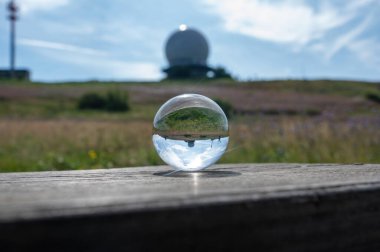 Radar kubbesinin yansıması olan tahta üzerine cam top. Almanya 'daki yüksek Rhoen' de Wasserkuppe 'nin zirvesinde kubbe. Mavi gökyüzü güneşli bir günde