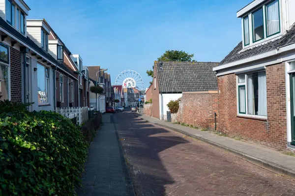 Egmond aan Zee, Hollanda, 2 Eylül 2024 - Şehirde mavi gökyüzü olan dönme dolap manzaralı küçük bir cadde