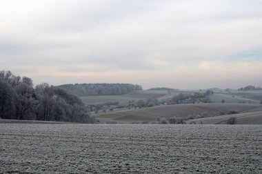 Soğuk bir kış gününde araziler, tarlalar ve çayırlarla kaplıdır.