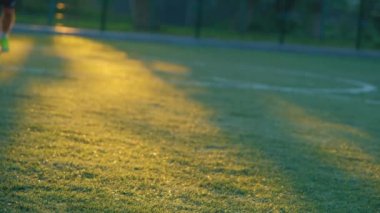 Futbol antrenmanı. Gün batımında futbol antrenmanı. Modern bir antrenman sahasında futbol oynamak.