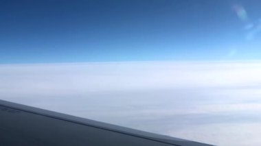 Pencereden geçen uçak kanadı. Uçakla bulutların üzerinde uçmak. Kanat ve bulutlardaki lombozdan bak.