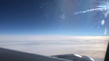 Pencereden geçen uçak kanadı. Uçakla bulutların üzerinde uçmak. Kanat ve bulutlardaki lombozdan bak.