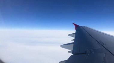 Pencereden geçen uçak kanadı. Uçakla bulutların üzerinde uçmak. Kanat ve bulutlardaki lombozdan bak.