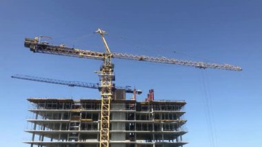 Çok katlı bir binanın inşaatı. Büyük, çok katlı bir bina inşa etme süreci. İnşaat alanında kule vinci.