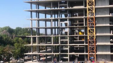 Çok katlı bir binanın inşaatı. Büyük, çok katlı bir bina inşa etme süreci. İnşaat alanında kule vinci.