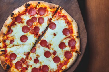 Peynirli ve diğer malzemeli lezzetli bir pizza resmi.