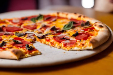 Peynirli ve diğer malzemeli lezzetli bir pizza resmi.