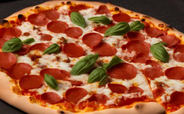 Peynirli ve diğer malzemeli lezzetli bir pizza resmi.