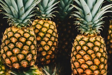 Yeşil yapraklı ve derili çiğ ananas resmi