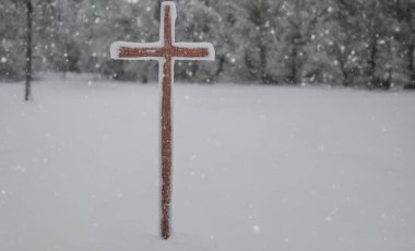 Hristiyan bir haçın karda karların üzerinde gerçekçi bir şekilde resmedilmiş hali.