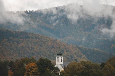 Pramo köyündeki kilisenin kalesi Beskydy dağlarının kalbinde, sabah sisi ve sonbaharda çevreleyen renkli dünya