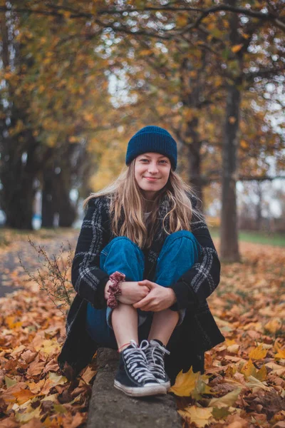 Усміхнена Щаслива Брюнетка Сидить Купі Барвистих Листя Міському Парку Відвертий — стокове фото