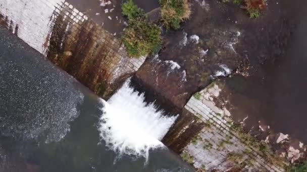 水が衝突し 泡立つシリンダーを形成するので 大きな川での弾幕の旋回する空中ショット 石垣を囲む滝 秋のシーズン 4Kビデオ — ストック動画