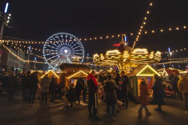 3.12. 2022 - Katowice, Polonya. Noel Marketi 'ndeki Noel süsleri Rynek, Katowice meydanındaki Advent sırasında. İçecek standı, insanlar ve dönme dolap ve çocuklar için diğer sürüşler.