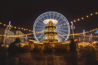 3.12. 2022 - Katowice, Polonya. Noel Marketi 'ndeki Noel süsleri Rynek, Katowice meydanındaki Advent sırasında. İçecek standı, insanlar ve dönme dolap..