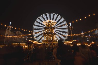 3.12. 2022 - Katowice, Polonya. Noel Marketi 'ndeki Noel süsleri Rynek, Katowice meydanındaki Advent sırasında. İçecek standı, insanlar ve dönme dolap..