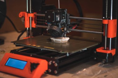 Yeni şeyler yapmak için teknolojik teg aleti. Siyah ve kırmızı 3D yazıcı iş başında. Nesne, madde katmanlarının katmanlarını katma süreçlerine yerleştirerek oluşturulur..