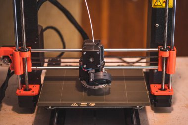 Yeni şeyler yapmak için teknolojik teg aleti. Siyah ve kırmızı 3D yazıcı iş başında. Nesne, madde katmanlarının katmanlarını katma süreçlerine yerleştirerek oluşturulur..