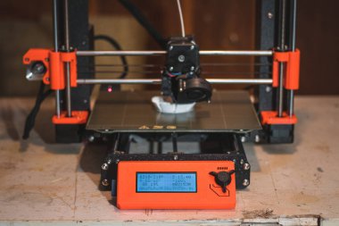 Yeni şeyler yapmak için teknolojik teg aleti. Siyah ve kırmızı 3D yazıcı iş başında. Nesne, madde katmanlarının katmanlarını katma süreçlerine yerleştirerek oluşturulur..