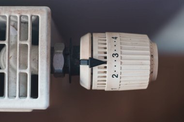 Bir apartman kompleksinde ısıtma için bir termoregülatör görünümü ve enerji krizi sırasında kalori değerinin azaltılması.