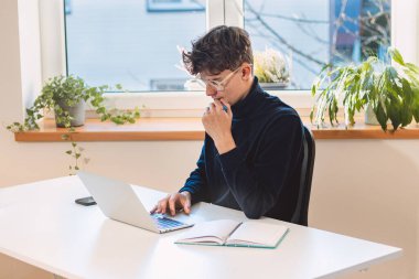 Entrepreneur is in his office thinking about his idea and implementing it in real time. Determining the start-up. Establishing a new online business.