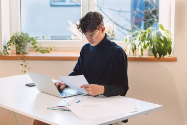 Brown-haired businessman transcribing his notes into his computer. A visionary puts his ideas into reality. Working from home. Online business.