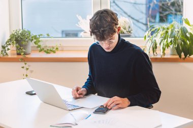 Brown-haired entrepreneur comes to the company with a new working concept, which he calculates with other technological accessories and writes his notes in his laptop.
