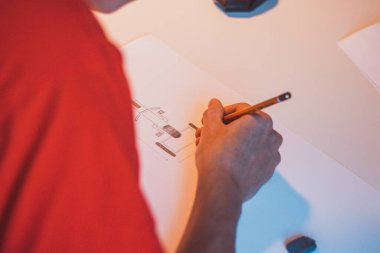 Brown-haired young architect creates new product designs for a new futuristic world. Working with your own creativity. Compass, pencil, ruler and paper. Creative home office.