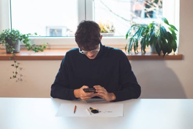 Brown-haired young architect creates new product designs for a new futuristic world. Working with your own creativity. Compass, pencil, ruler and paper. Creative home office.