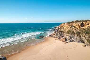 Portekiz 'in Odemira kenti Vila Nova de Milfontes yakınlarındaki Atlantik kıyısındaki Praia da Angra da Cerva kumsalını saran uçurumlar nefes kesicidir. Rota Vicentina 'nın izinden. Balıkçı patikası.