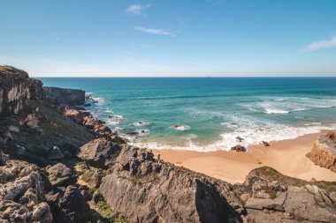 Portekiz 'in Odemira kenti Vila Nova de Milfontes yakınlarındaki Atlantik kıyısında Praia do Malhao Sul' un kumlu plajını kayalar çevrelemektedir. Rota Vicentina 'nın izinden. Balıkçı patikası.