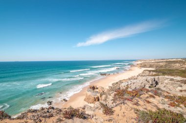 Portekiz 'in Odemira kenti Vila Nova de Milfontes yakınlarındaki Atlantik kıyısında Praia do Malhao Sul' un kumlu plajını kayalar çevrelemektedir. Rota Vicentina 'nın izinden. Balıkçı patikası.