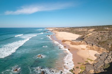 Portekiz 'in Odemira kenti Vila Nova de Milfontes yakınlarındaki Atlantik kıyısında Praia do Malhao Sul' un kumlu plajını kayalar çevrelemektedir. Rota Vicentina 'nın izinden. Balıkçı patikası.