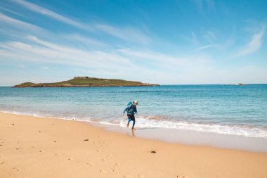 Porto Covo, Portekiz yakınlarındaki kumlu bir plajda Atlantik Okyanusu 'nun dalgalarından kaçan genç, tutkulu siyah saçlı dobby. Rota Vicentina 'nın izinden..