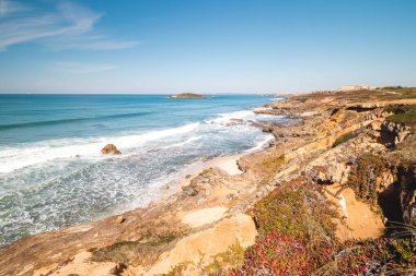 Portekiz 'in Odemira kenti Vila Nova de Milfontes yakınlarındaki Atlantik kıyısında Praia do Malhao Sul' un kumlu plajını kayalar çevrelemektedir. Rota Vicentina 'nın izinden. Balıkçı patikası.