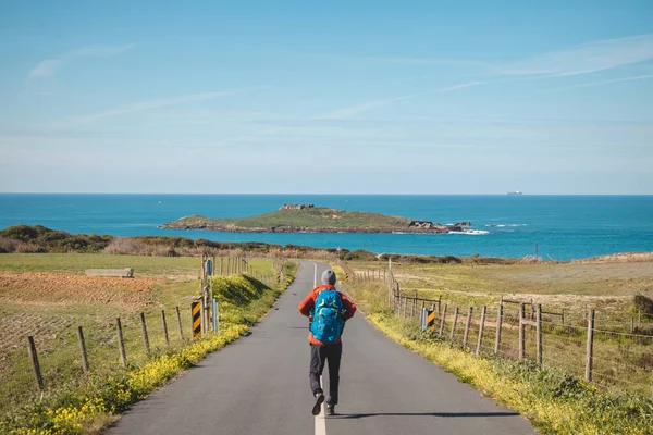 stock image Man full of enthusiasm embarks on his journey along the Fisherman trail - Rota Vicentina along the Atlantic coast of Portugal. Adventurous backpacker hits the road in the spring months.