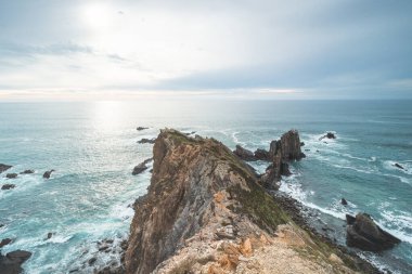 Portekiz 'in batısındaki Ohexe kasabası yakınlarındaki Atlantik Okyanusu kıyısındaki Algarve' nin ünlü turistik bölgesinde engebeli kaya ve uçurum. Gün batımı.