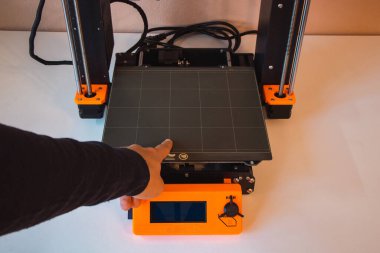 Yeni şeyler yapmak için teknolojik teg aleti. Siyah ve kırmızı 3D yazıcı iş başında. Nesne, madde katmanlarının katmanlarını katma süreçlerine yerleştirerek oluşturulur...