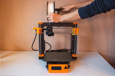 Yeni şeyler yapmak için teknolojik teg aleti. Siyah ve kırmızı 3D yazıcı iş başında. Nesne, madde katmanlarının katmanlarını katma süreçlerine yerleştirerek oluşturulur...